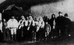 5. A keresztelre egybegyltek csoportja, a komaasszonyok kezben 