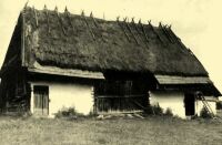 82. Barn built of logs with a thatched roof